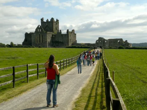 Il gruppo cammina lungo un sentiero verso le rovine di un'abbazia, in Irlanda
