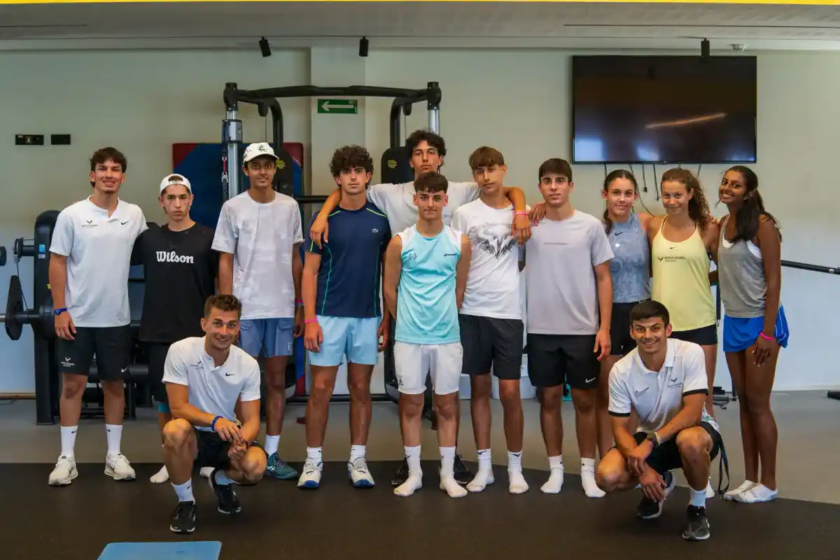 Il gruppo di ragazzi con i due allenatori nella palestra della Rafa Nadal Academy