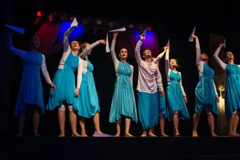 Ballerine in scena lanciano aeroplanini di carta