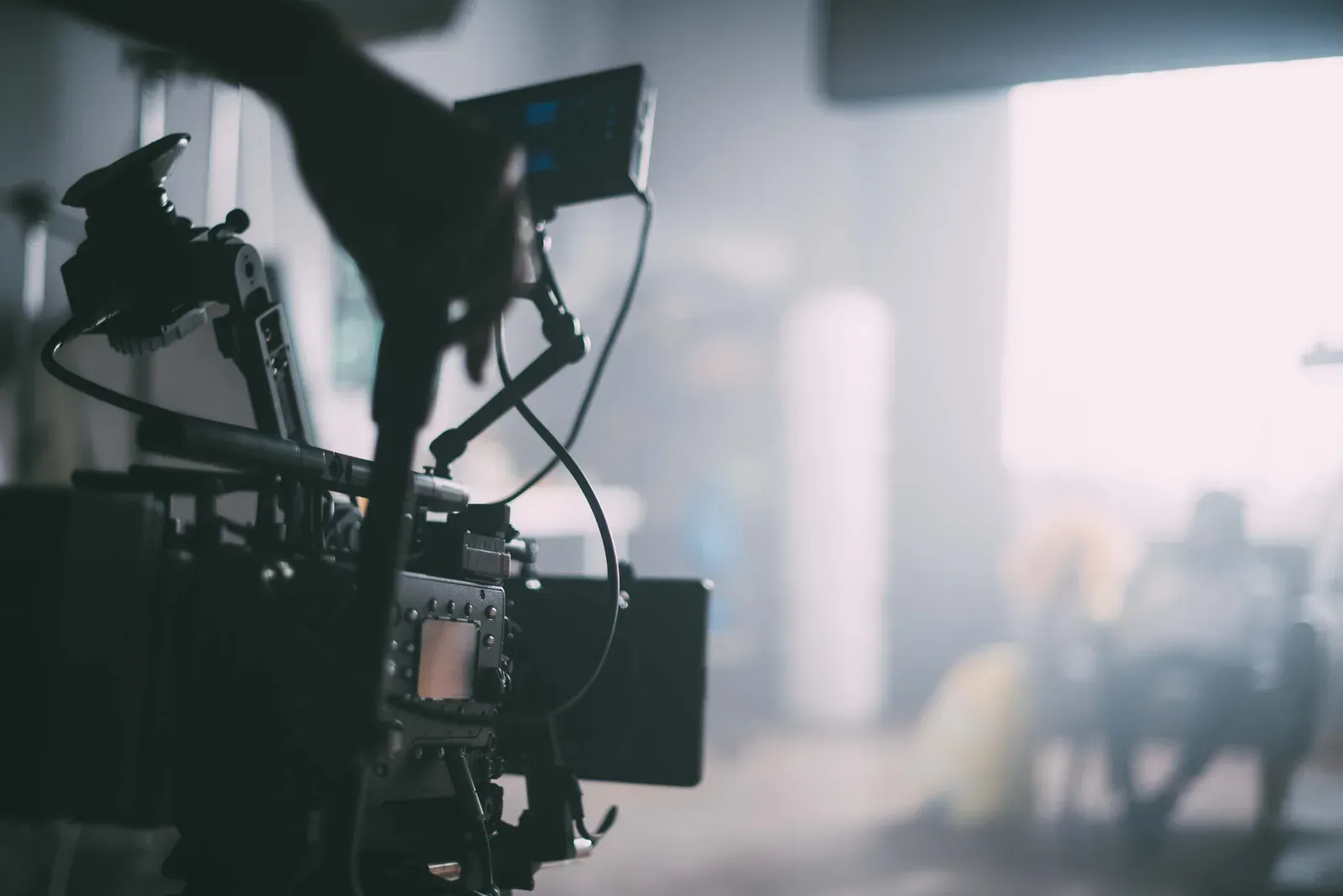 Una cinepresa professionale sul set, con le luci accese dietro