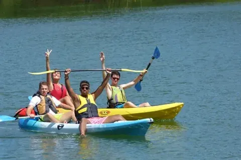 Ragazzi in kayak alzano le pagaie sull'acqua