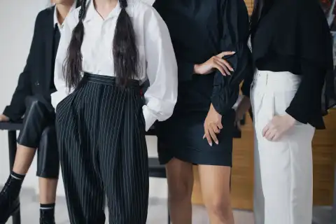 Modelle in abiti bianchi e neri durante una prova di moda