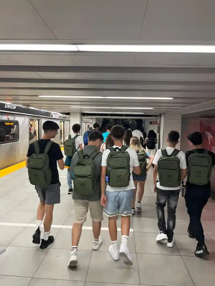 Studenti con lo zaino camminano lungo la banchina della metropolitana