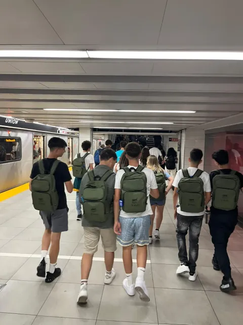 Studenti con lo zaino camminano lungo la banchina della metropolitana